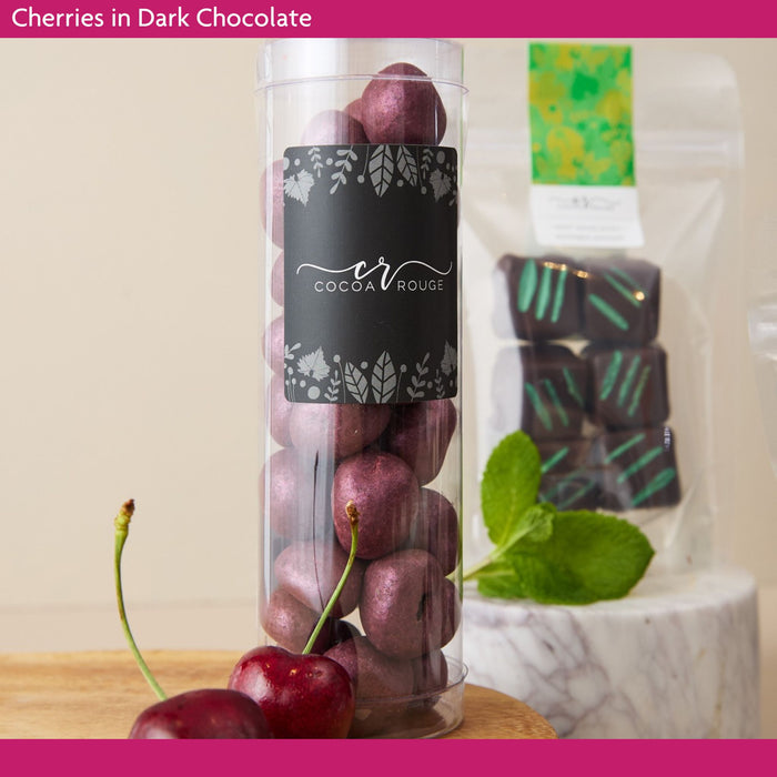Dark chocolate cherries in a cylindrical container.