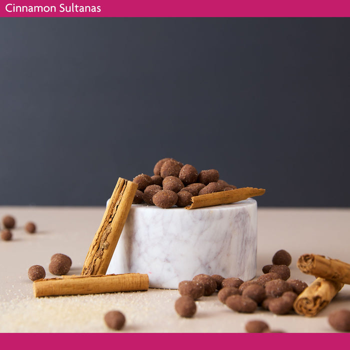 Cinnamon sultanas in a marble bowl with cinnamon sticks on a dark background