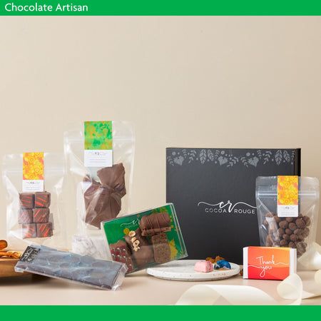 Chocolate products including wrapped chocolates and a box with 'Cocoa Rouge' branding on a neutral background.  Chocolate Artisan