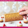 Chocolate bar with 'Happy Birthday' text held by a hand, surrounded by cupcakes.