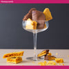 Glass dish with chocolate-dipped honeycomb on a dark background