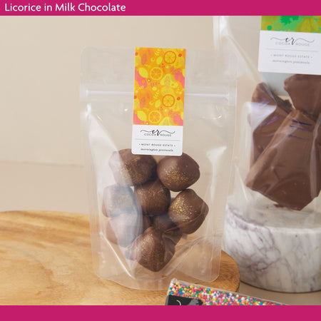 Packaged licorice in milk chocolate on a wooden surface