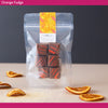 Packaged orange fudge with decorative label on a neutral background
