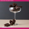 Glass with dark chocolate clusters on a neutral background