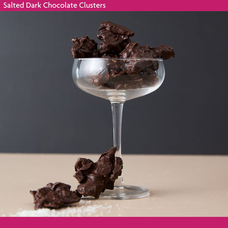 Glass with dark chocolate clusters on a neutral background