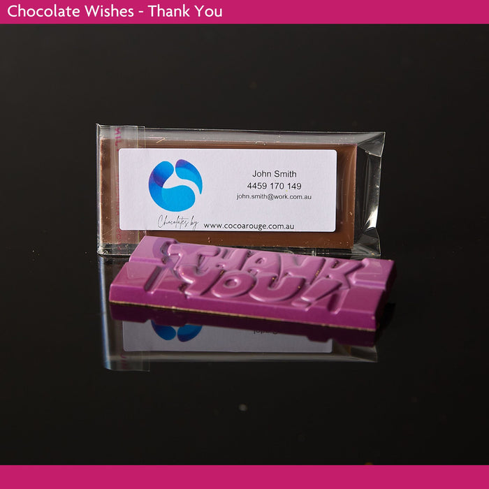 Chocolate bar with 'Thank You' text and a business card on a reflective surface