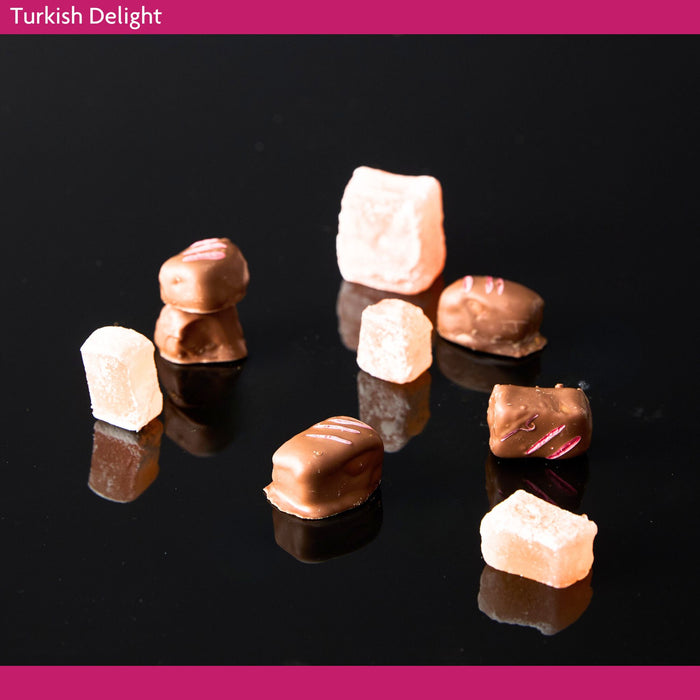 Turkish Delight pieces on a black background coated in milk chocolate