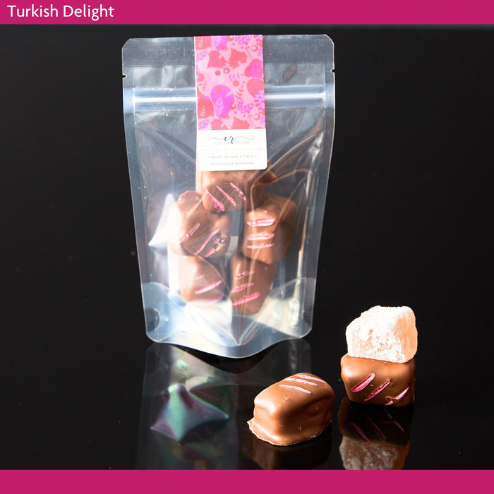 Turkish delight coated in milk chocolate in clear packaging with a pink label on a black background